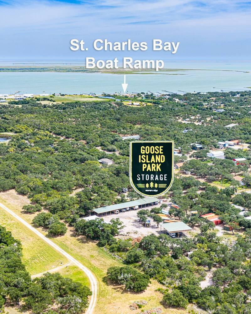 Aerial photo with the Goose Island Park Storage sign over the yard and an arrow to the St. Charles Bay boat ramp on the shoreline beyond